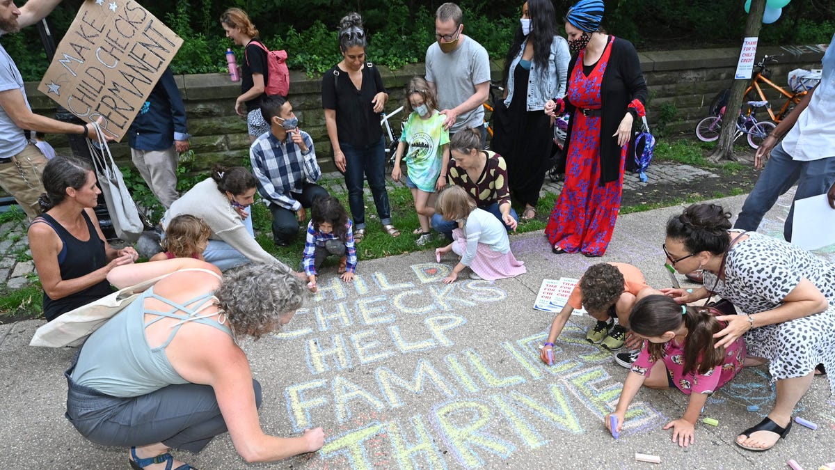 Parents and children celebrate new monthly Child Tax Credit payments and urge congress to make them permanent outside Senator Schumer's home on July 12, 2021 in Brooklyn, New York.