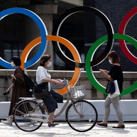 People walk by the Olympic rings installed by the 