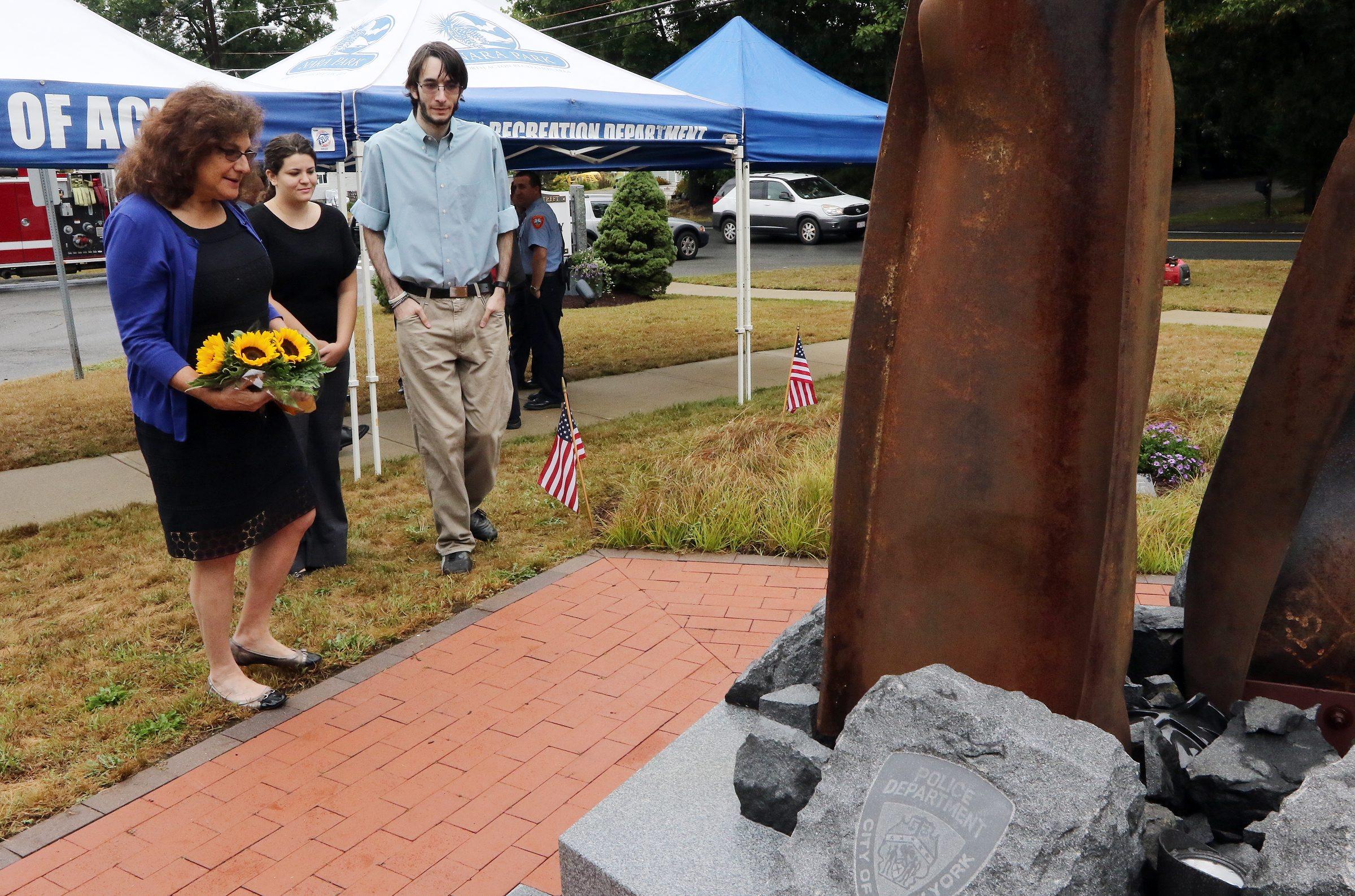 Lauren Rosenzweig Morton, the widow of 9/11 victim Philip Rosenzweig, attends a remembrance ceremony at the Acton Sept. 11 memorial in 2015, accompanied by her son and daughter-in-law.