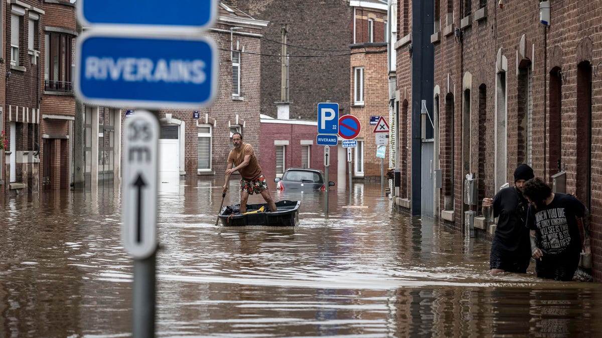 A man rows a boat down a residential street after flooding in Angleur, Province of Liege, Belgium, Friday July 16, 2021. Severe flooding in Germany and Belgium has turned streams and streets into raging torrents that have swept away cars and caused houses to collapse. (