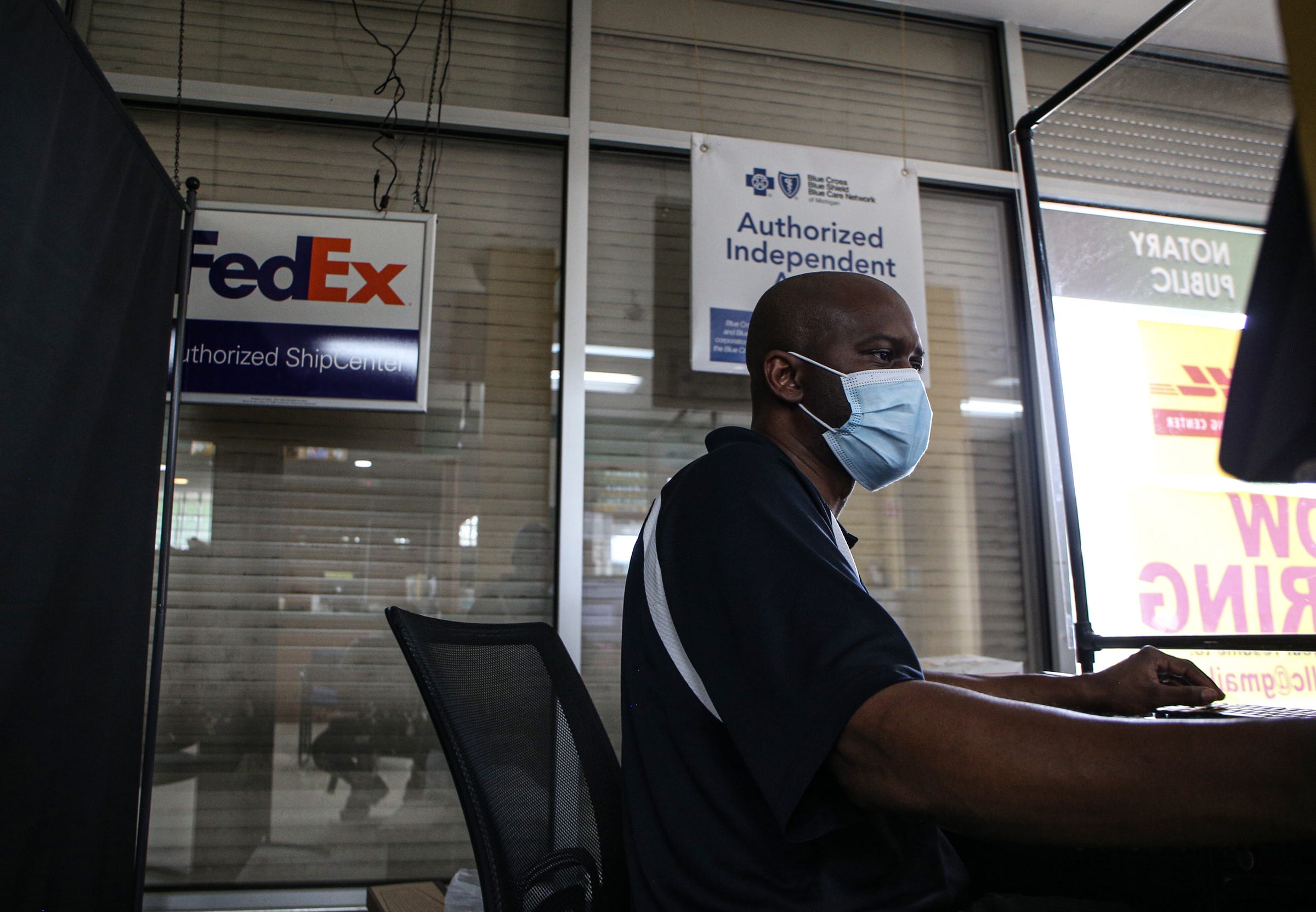 Mario Hall helps a customer at Hallstarz Business Center in Detroit on July 15, 2021. The business center is a one-stop-shop in the Bagley neighborhood. A neighborhood source for packing, shipping, printing and other business services. Created 36 years ago by a Detroit couple, Milton Hall Jr. and Vanessa Hall. The business is now run by their oldest son, Mario Hall with help from his five brothers.