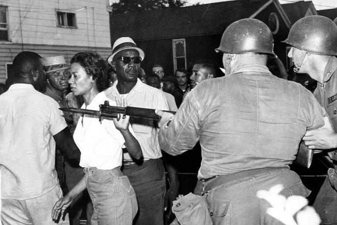 FILE - In this July 21, 1963, file photo, Gloria Richardson, head of the Cambridge Nonviolent Action Committee, pushes a National Guardsman's bayonet aside as she moves among a crowd of African Americans to convince them to disperse in Cambridge, Md. Richardson, an influential yet largely unsung civil rights pioneer whose determination not to back down while protesting racial inequality was captured in a photograph as she pushed away the bayonet of a National Guardsman, died Thursday, July 15, 2021, in New York, according to Joe Orange, her son in law. She was 99.