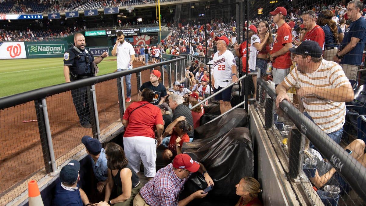Fans take cover after an apparent shooting occurred outside Washington's Nationals Park.
