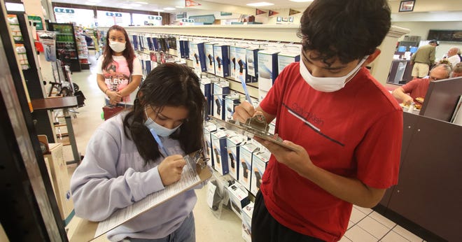 Thirteen-year-old Jacquelin Hernandez and her older brother Edgar Hernandez, 17, fill out paperwork prior to getting their COVID-19 vaccinations Monday afternoon, July 19, 2021, at Medical Center Pharmacy on Cox Road.