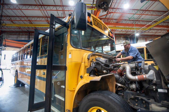 Mechanic Joey Wood works on a school bus Monday at the Escambia County School District Transportation Department in Pensacola.
