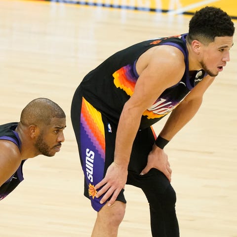 Suns guard Chris Paul (left) stands next to guard 
