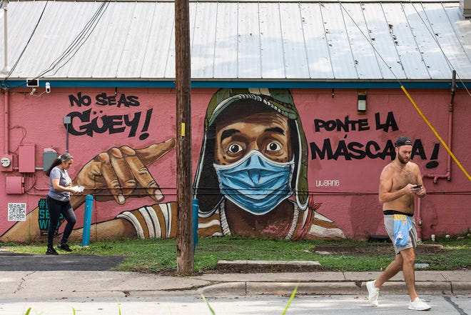 A mural painted on Marcelino's East Austin restaurant in July tells people to wear masks.  The guidelines could be relaxed next week.