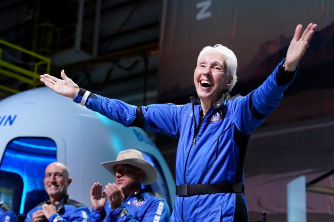 Wally Funk, right, describes their flight experience as Mark Bezos, left, and Jeff Bezos, left, center, founder of Amazon and space tourism company Blue Origin, applaud from the spaceport near Van Horn, Texas, Tuesday, July 20, 2021. (AP Photo/Tony Gutierrez)
