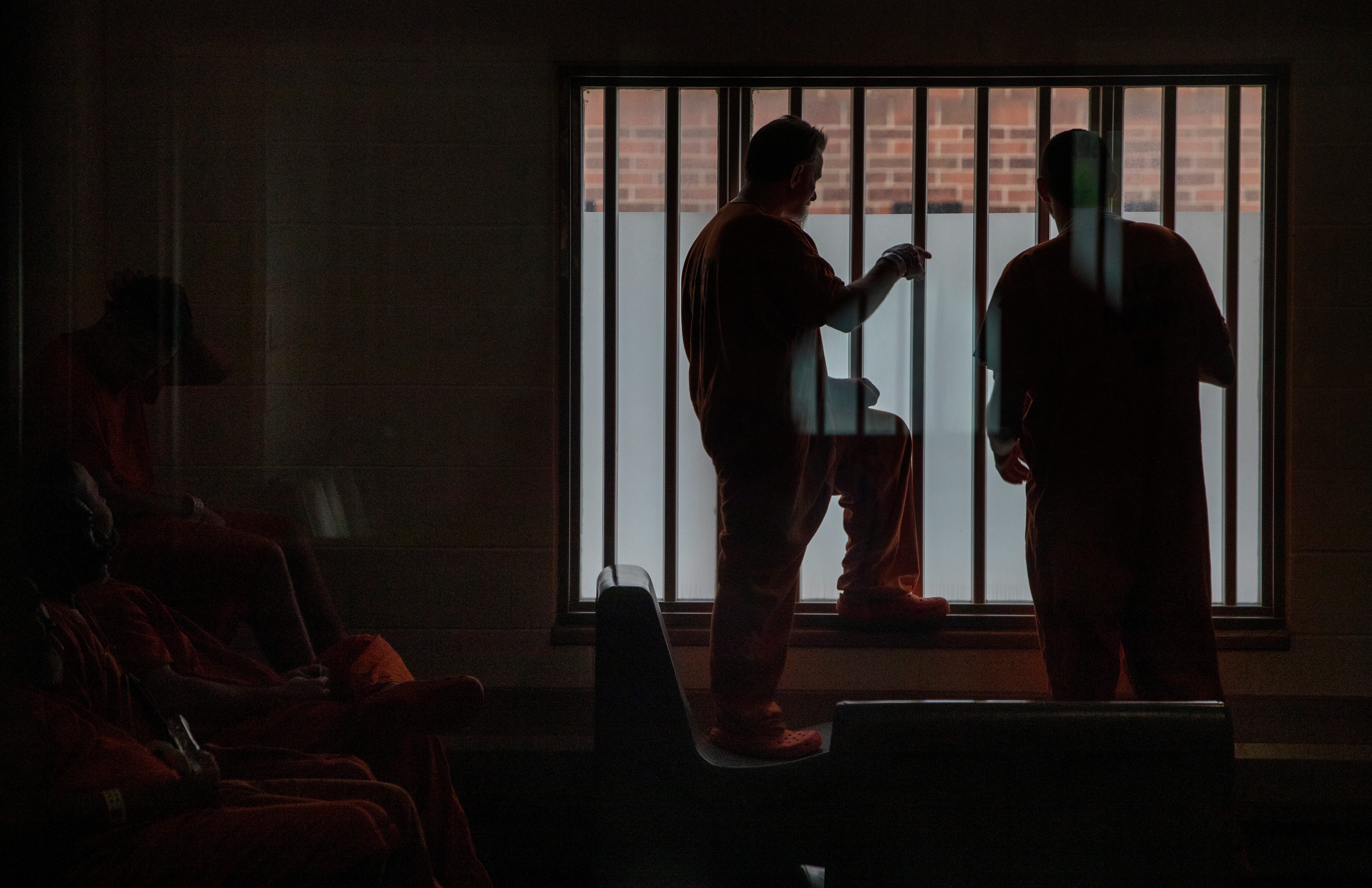 Detainees stand near a window Thursday, June 24, 2021, at the Allen County Jail in downtown Ft. Wayne, Ind.