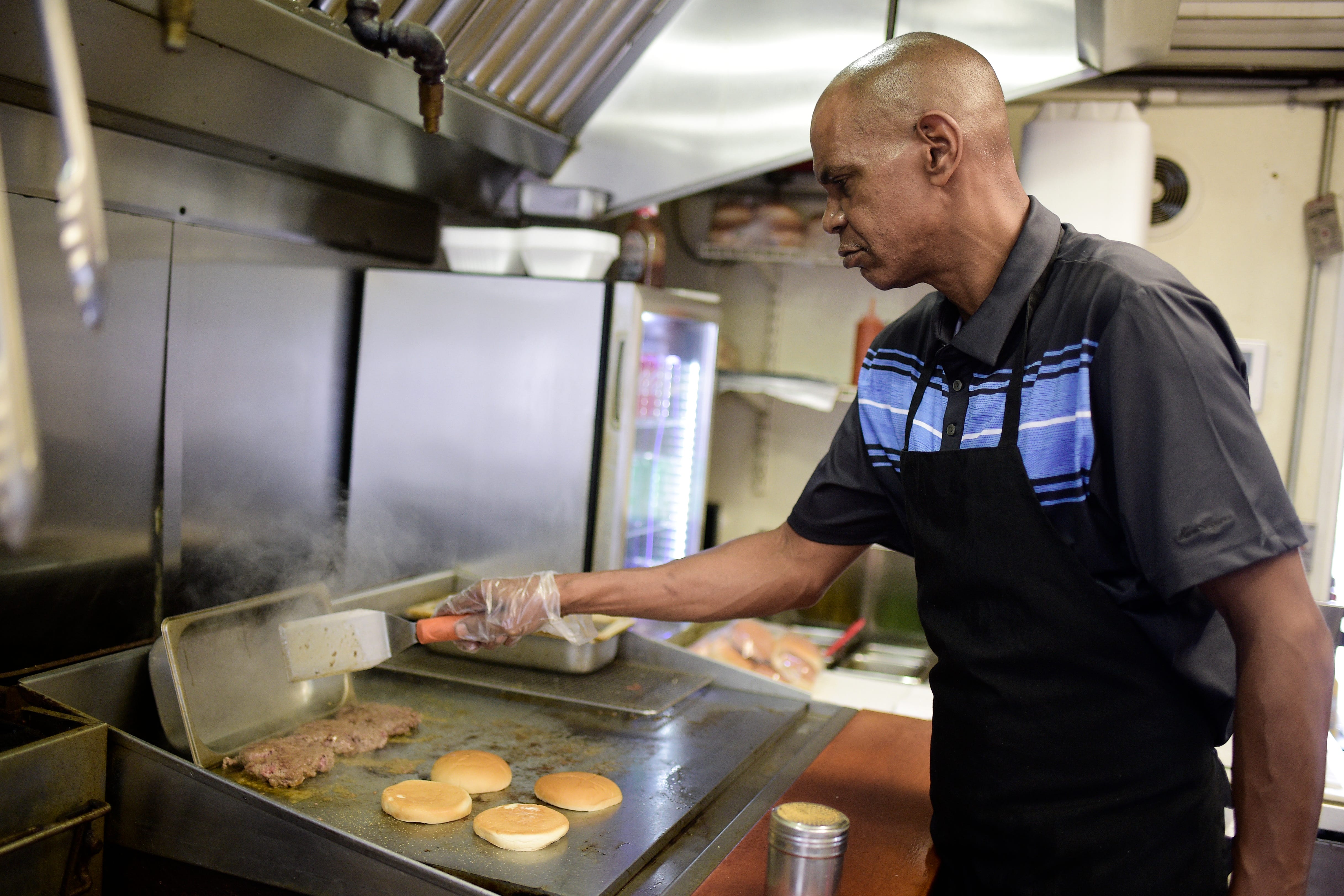 Andre Bryant's day doesn't start when the restaurant opens at 11 a.m. He arrives hours before the first customers line up to prepare food for the day, which includes putting together each hamburger patty by hand.