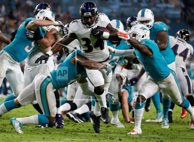Miami Dolphins players attempt to tackle Baltimore Ravens running back Lorenzo Taliaferro (34), during the second half of an NFL preseason football game, Thursday, Aug. 17, 2017, in Miami Gardens, Fla. (AP Photo/Lynne Sladky)