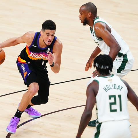 Suns guard Devin Booker (1) moves the ball against