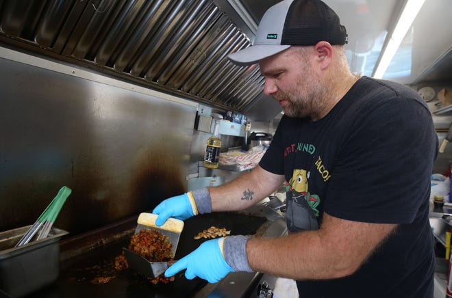 Roman Marinov, owner of the Tacomania Food Truck, prepares food while the truck was at the Ricart Auto Mall on July 20. His truck will be included in the Columbus Food Truck Festival from Aug. 21-22 at the Franklin County Fairgrounds in Hilliard.