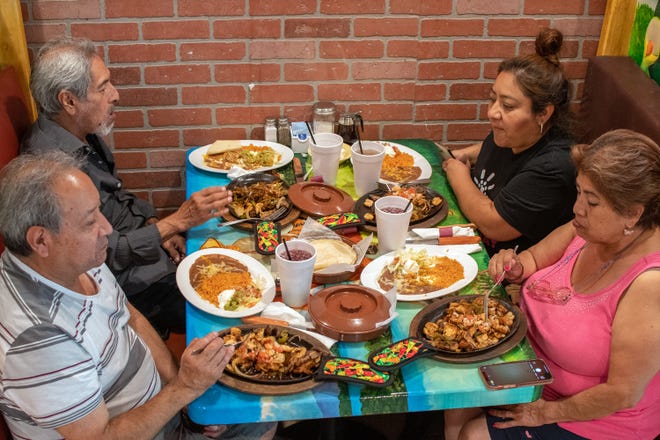 Framingham residents (clockwise, from bottom left) Pablo Sontai, Angel Ponce, Jhoana Sontai and Mirna Ponce  enjoy their meals at Tacos & More, a new restaurant that recently opened on Waverly Street in Framingham.