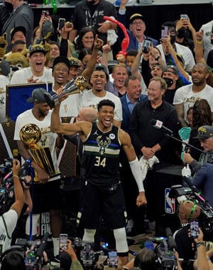 Milwaukee Bucks forward Giannis Antetokounmpo (34) holds his FINALS MVP Trophy as Milwaukee Bucks forward Khris Middleton (22) holds Larry O'Brien NBA Championship Trophy after the Bucks won Game 6 of the NBA Finals at Fiserv Forum in Milwaukee on Tuesday, July 20, 2021.