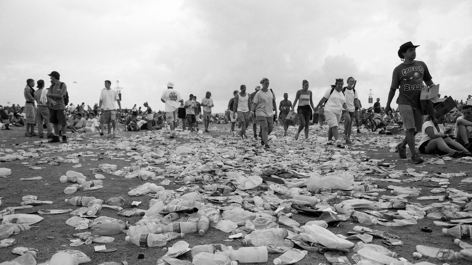 Woodstock 99 attendees walk along piles of trash at Griffiss Air Force Base in Rome, New York.