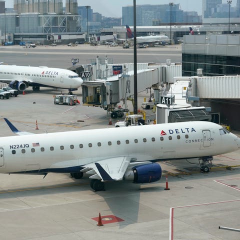 Delta Air Lines passenger jets rest on the tarmac,