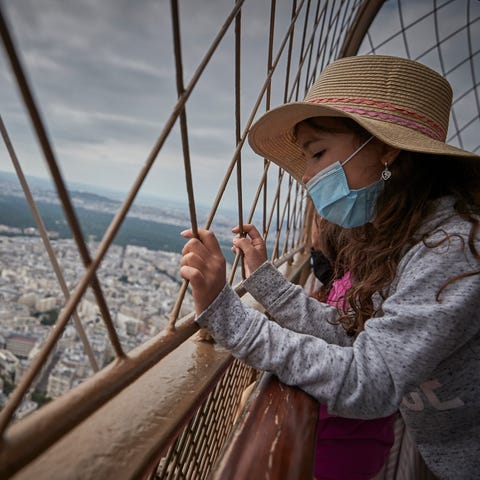 A girl looks down at Paris from the top of the Eif