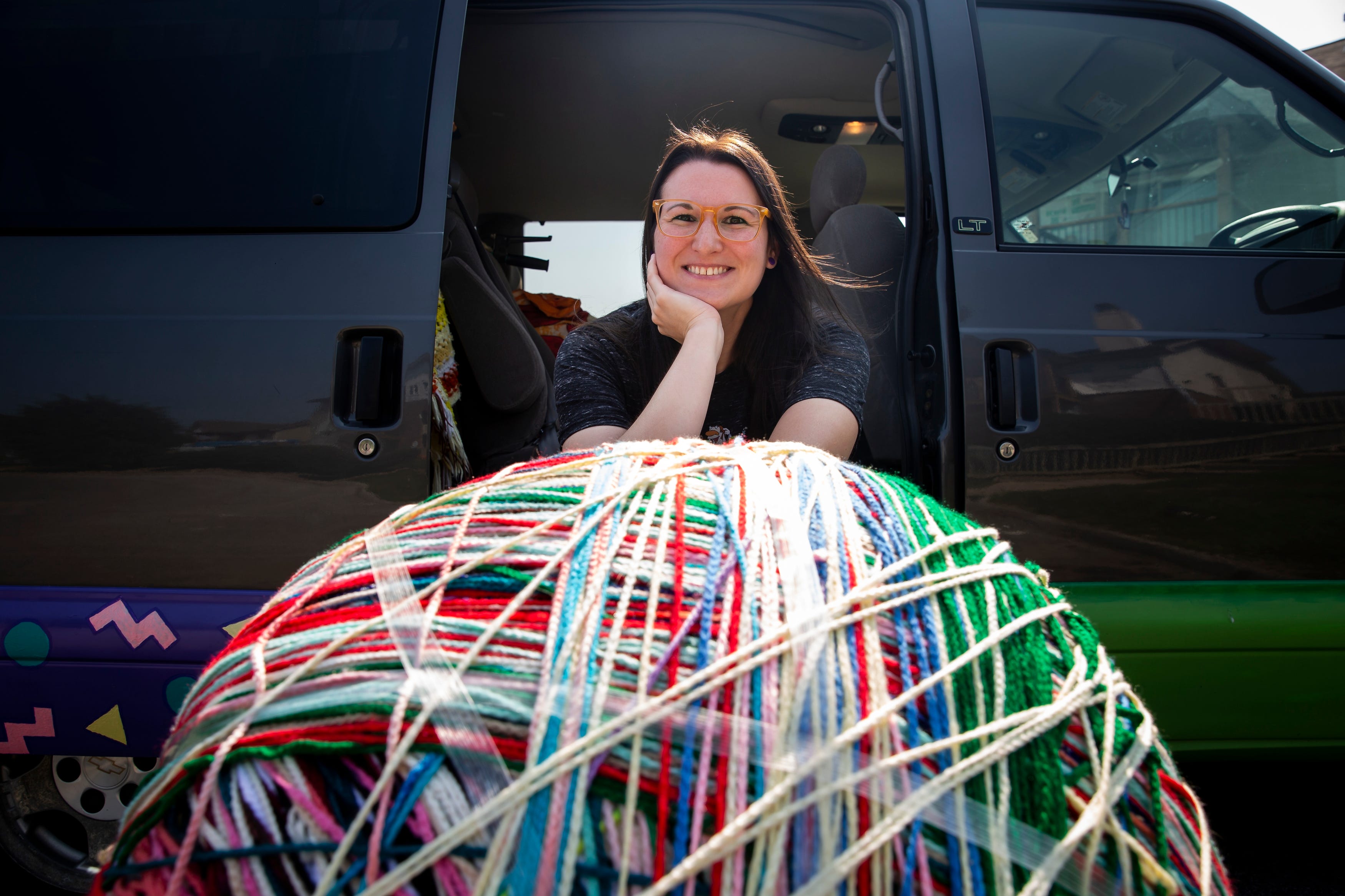 Abby Niederhauser started working on her more than 200-pound ball of yarn when she was 10. Here she poses for a photo with the ball at her West Des Moines home in 2021. The ball was started by wrapping yarn around a note she wrote thanking all the people who helped her start the project.
