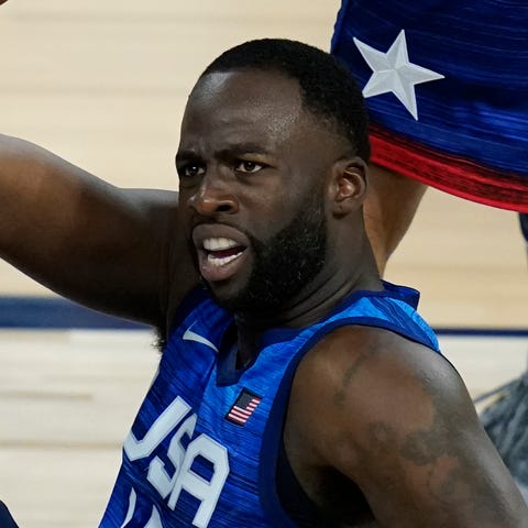 United States' Draymond Green is helped off the gr