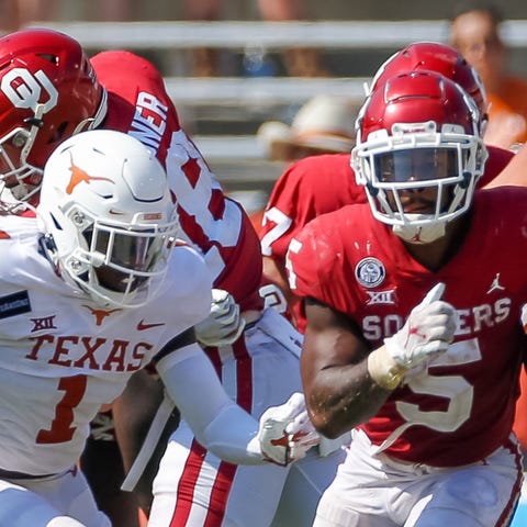Oklahoma running back T.J. Pledger (5) breaks thro