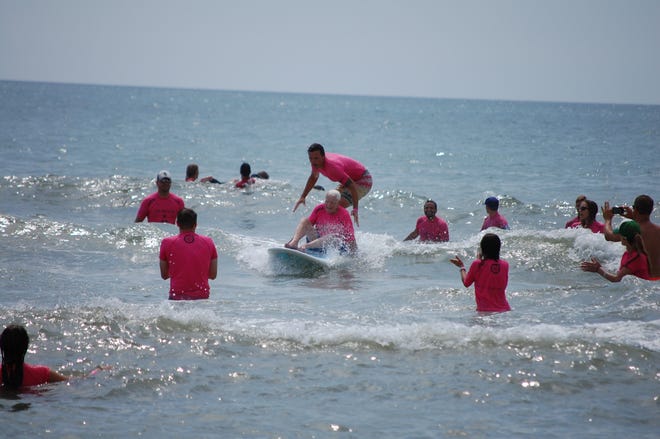 Ocean Cure volunteers assist senior citizens at the beach.