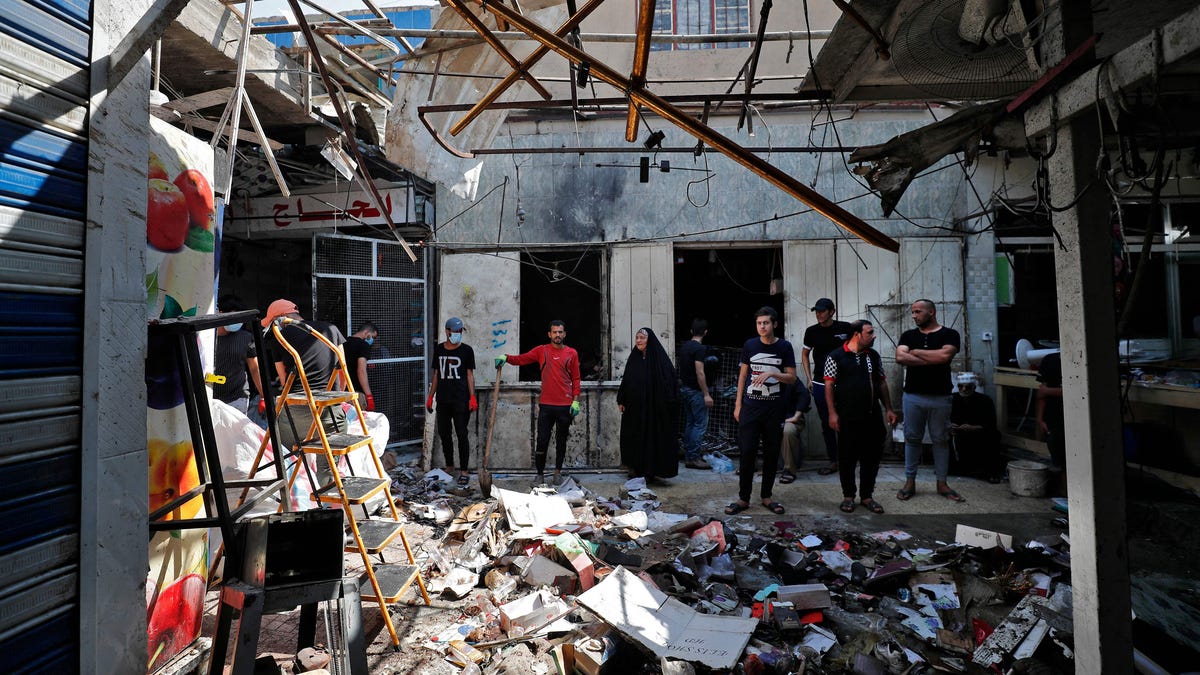 Iraqis inspect the site of an explosion in a market in the Shiite-majority Sadr City neighborhood, east of the capital Baghdad, on July 20. Iraqis mourned at least 36 people killed when a bomb ripped through the market in what Islamic State jihadists claimed was a suicide attack.