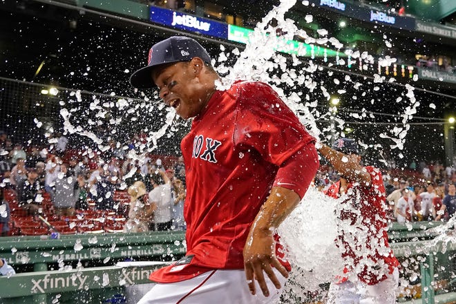 Boston Red Sox's Rafael Devers is doused with ice water to celebrate the team's 6-2 victory over the New York Yankees Friday at Fenway Park.