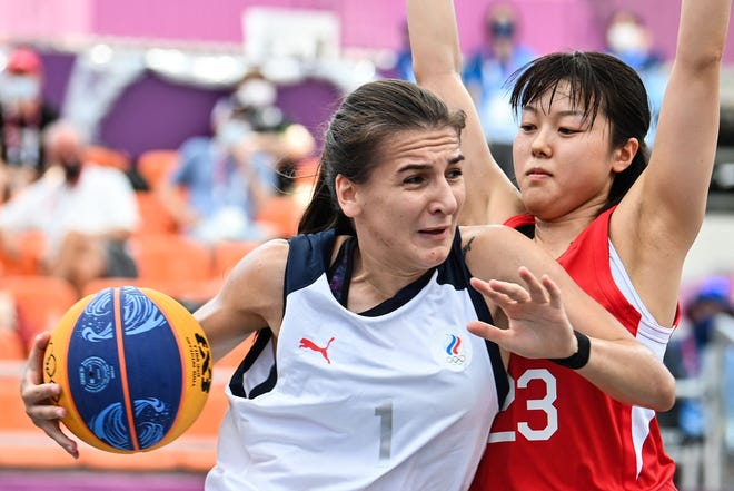 La Russe Yulia Kozik (L) et la Japonaise Mai Yamamoto se battent pour le ballon lors du premier tour féminin de basket-ball 3x3.