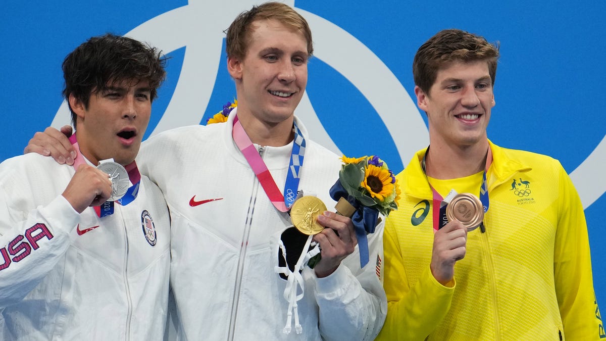 Men's 400 meter IM medalists Jay Litherland, left, and Chase Kalisz, center, of the U.S. and Brendon Smith of Australia go maskless during the post-race medal ceremony.