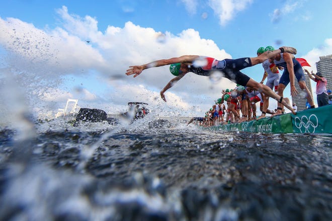 Ledecky wins silver; men's 4x100 gets gold 6 Some athletes dive into the water while others are blocked by a broadcast boat in the men's individual triathlon competition during the Tokyo 2020 Olympic Games.