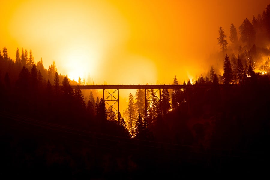 The Dixie Fire burns behind a bridge in Plumas County, Calif., on July 25.