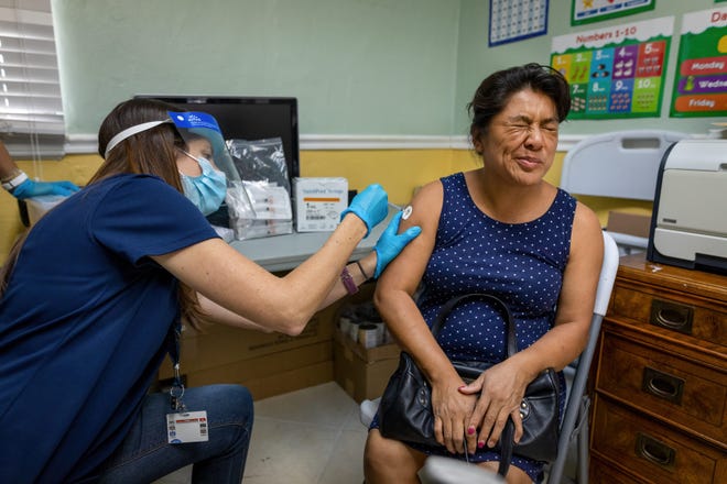 Walmart pharmacist Lauren Payne administers a Covid-19 vaccine to Evilia Morales Lappara at the Esperanza Community Center in West Palm Beach, Florida on May 19, 2021.  GREG LOVETT/PALM BEACH POST