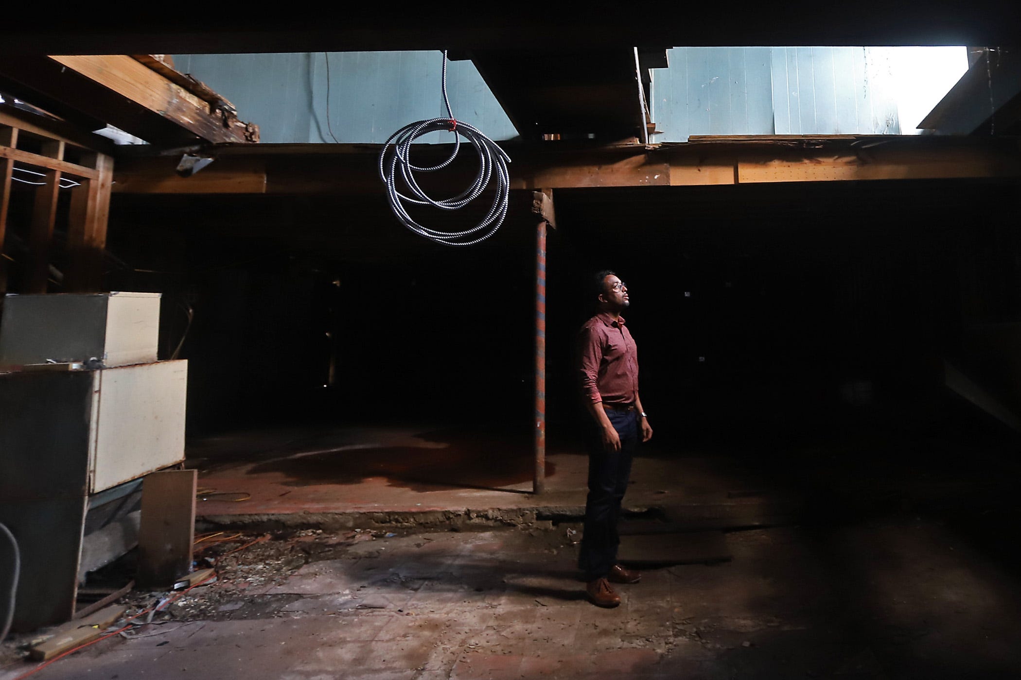 Curtis Doucette Jr. looks up at part of the ceiling that had fallen in at the historic hotel and nightclub The Dew Drop Inn in New Orleans. He plans to turn the place into a boutique hotel.