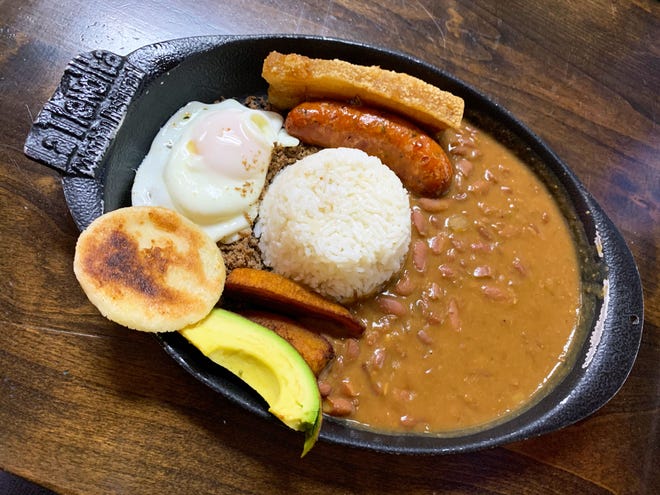 La Tiendita는 파삭 파삭 한 삼겹살, 초리소 소시지, 콩 및 계란의 큰 요리 인 콜롬비아의 국가 요리 인 bandeja paisa를 제공합니다.