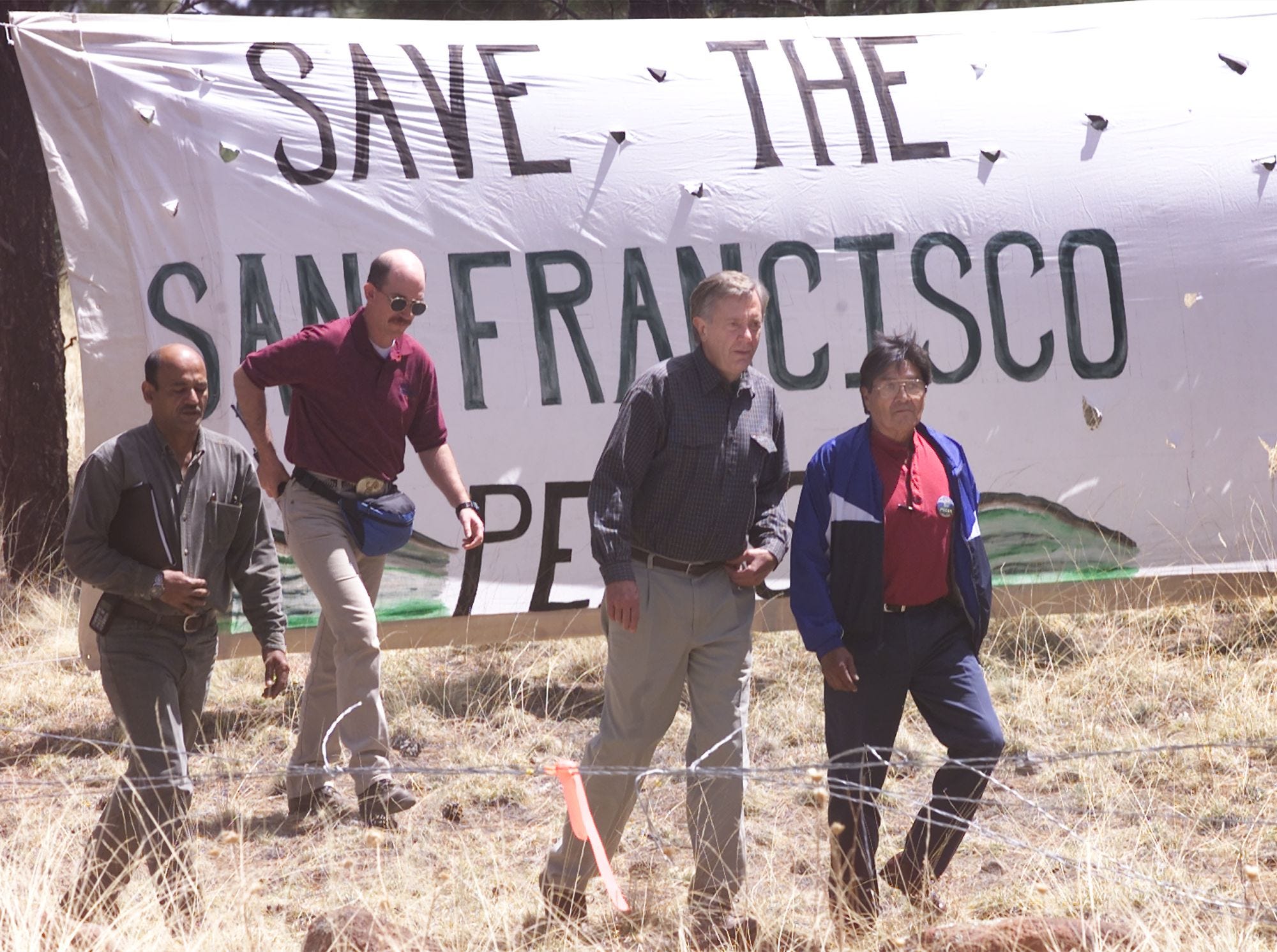 Bruce Babbitt (left), then-secretary of the Interior Department; Ferrell Secakuku, former chairman of the Hopis; and members of Babbit's party walk toward the White Vulcan Mine.