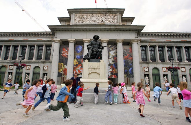 Children play around the statue of famed Spanish artist Diego Velasquez in front of the Prado museum in Madrid in this file photo from May 21. 2004.