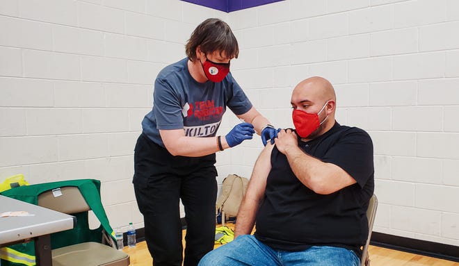A Team Rubicon volunteer administers a shot at mobile vaccination site in May.