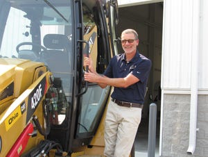 Mark Nemec, public-services director for New Albany, stands on a backhoe, one of several pieces of heavy equipment that will be on display for the Aug. 21 Touch-A-Truck event.
