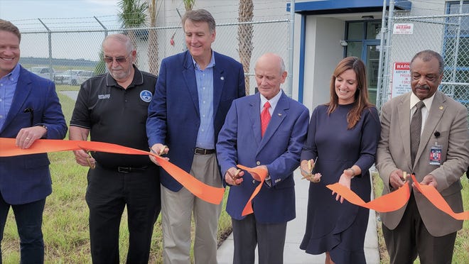 Retired NASA astronaut Norman Thagard (center in blue jacket) joins Lt. Gov. Jeanette Nunez (black dress) and other Jacksonville business and airport officials at the grand opening of the Cecil Spaceport's new control tower and mission control.