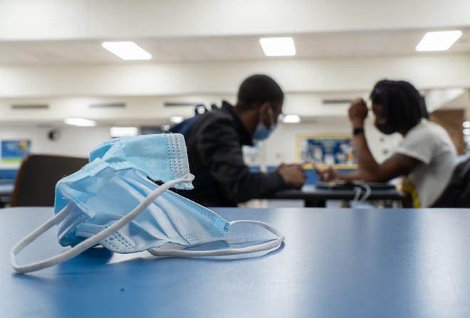 2021年6月16日水曜日にフリントのハマディ高校で昼食をとっている間、ハマディ高校のイーサンシールド(右)と若いアミールジョーンズが話している間、フェイスマスクがテーブルの上に置かれています。