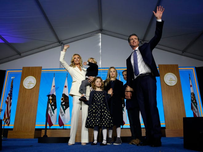 California Governor Gavin Newsom his wife, Jennifer Siebel Newsom, and their children wave after taking the oath of office during his inauguration as 40th Governor of California, in Sacramento, Calif, on Jan. 7, 2019.