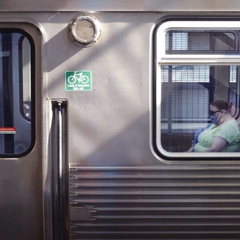 A commuter wears a face mask as she rides an L tra