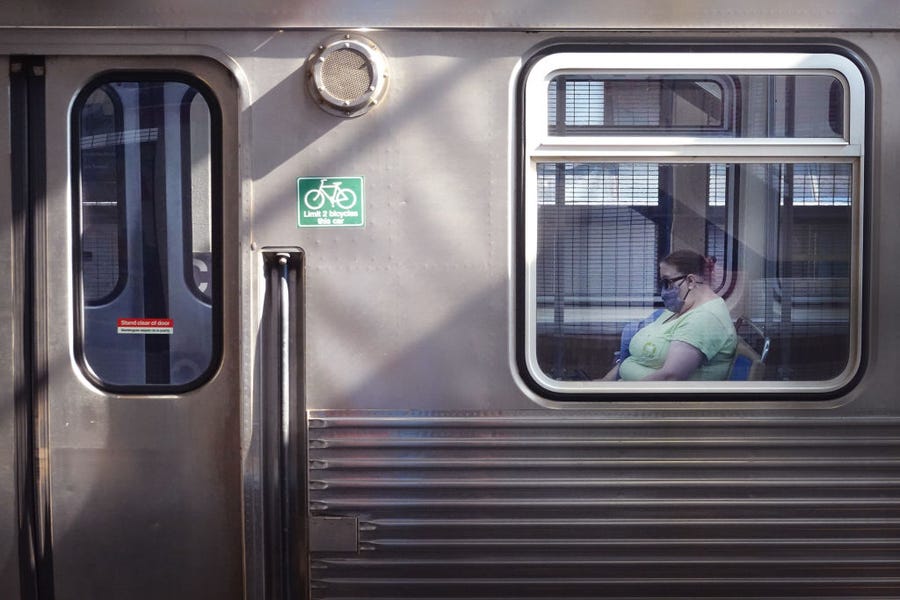 A commuter wears a face mask as she rides an L train through the Loop on July 27, 2021 in Chicago, Illinois. The Centers for Disease Control and Prevention (CDC) is expected to recommend that fully vaccinated people begin wearing masks indoors again in places with high Covid-19 transmission rates as the delta variant begins to cause a spike in coronavirus cases in some regions of the country.