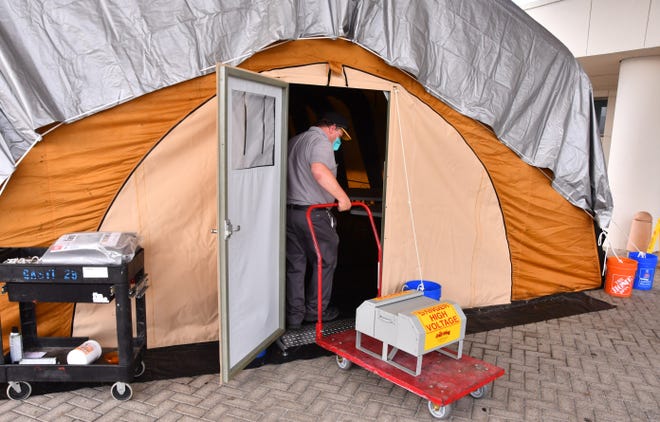 Health First sets up tents outside emergency rooms at Holmes Regional Medical Center and Palm Bay Hospital on July 27 in Florida. The tents will be used to separate people coming to the ER with COVID-19 symptoms from other patients.