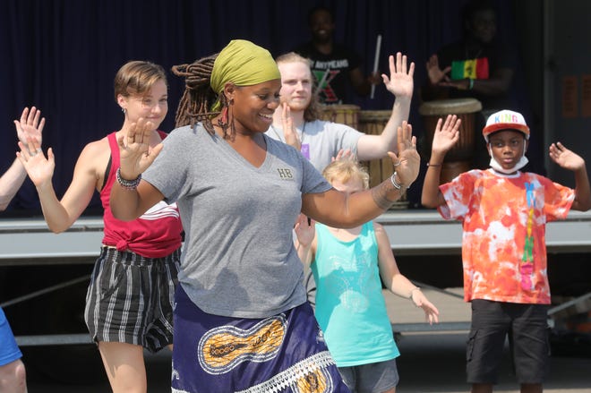Talise Campbell, artistic director of Djapo Cultural Arts Institute of Cleveland, dances with children and dancers Wednesday at Akron's Joy Park.