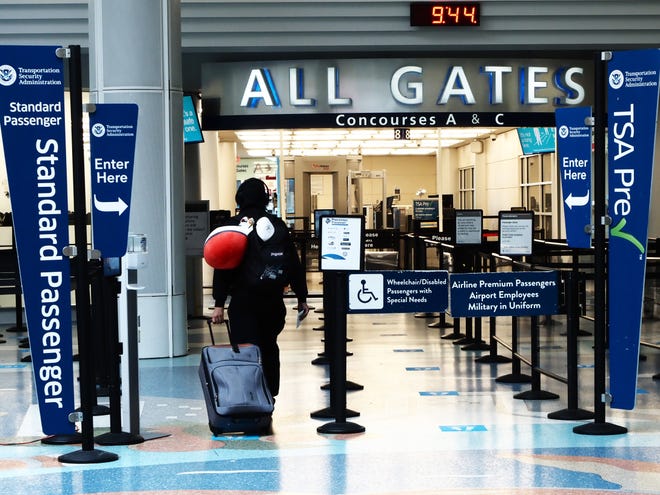 A traveler in this file photo walks toward the 20 gates that Jacksonville International Airport has in Concourse A and Concourse C. The Jacksonville Aviation Authority wants to finish design for Concourse C that would add room for 12 more gates if built.