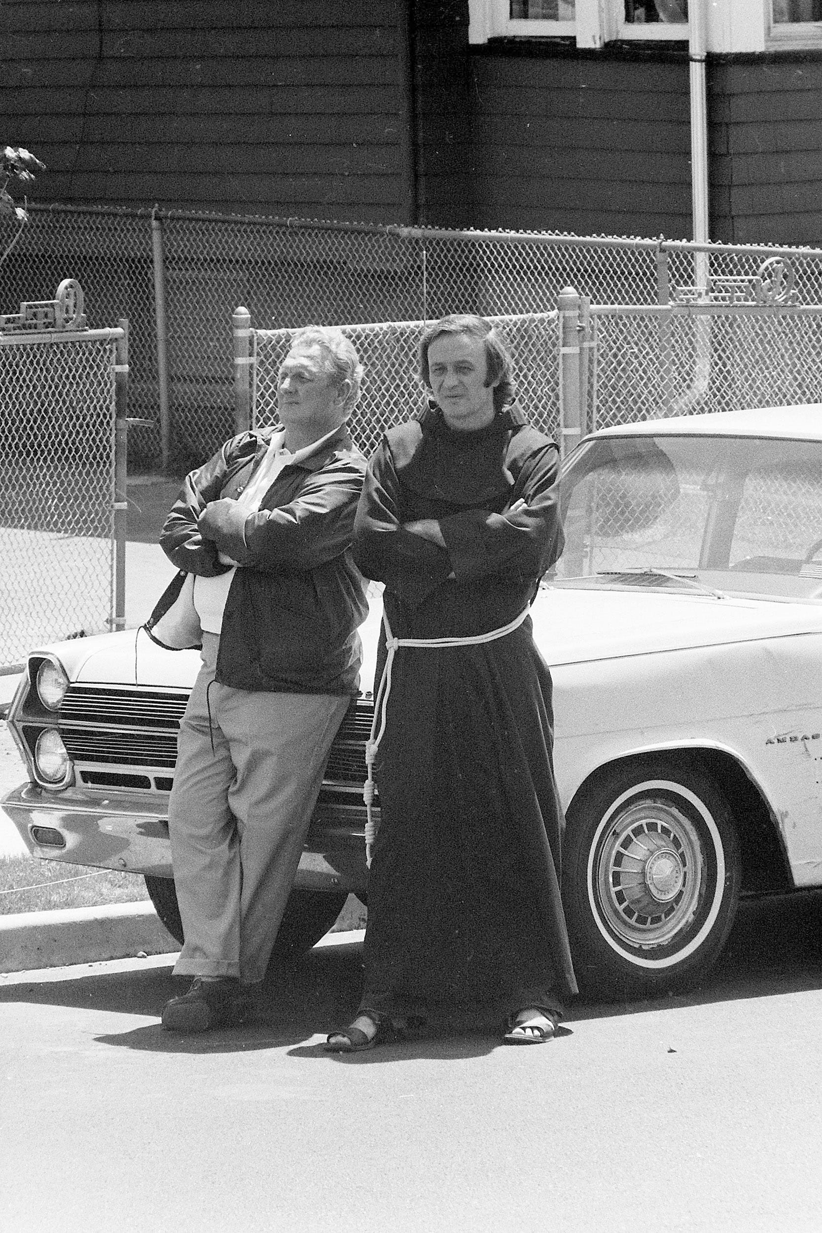 Judge Fred C. Galda and Father Mychal Judge wait between negotiations during a police standoff with James G. Hyams who was holding his wife and their three children hostage in his wife's home with a shotgun and two handguns in Carlstadt, N.J., on May 19, 1974. During the all-day seige, Hyams had fired three shots and police fired one. No one was injured.