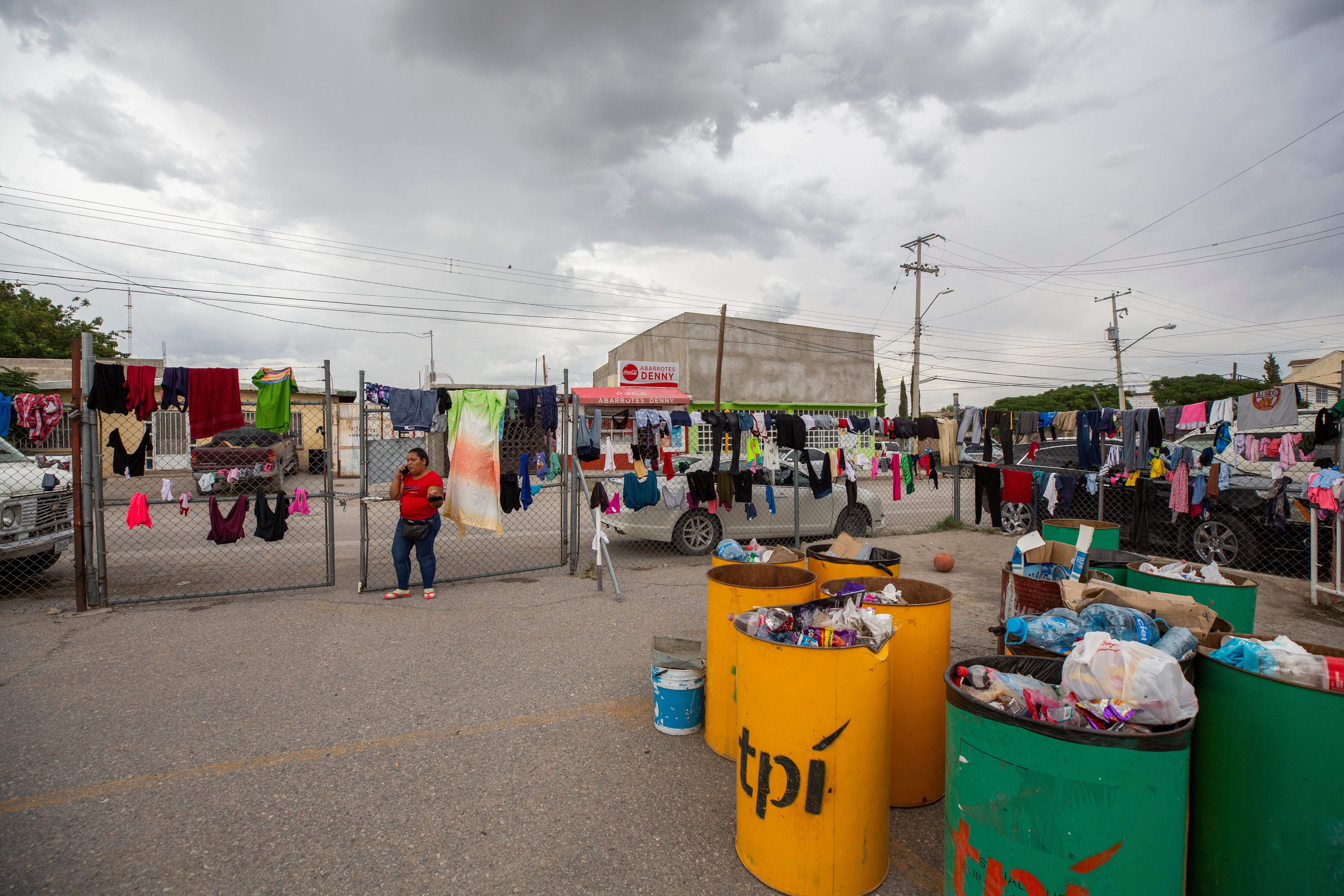 Bins containing trash and a fence used for drying clothing are seen at the Enrique "Kiki" Romero shelter in Juarez on Monday as more than 300 migrants, many of them farmworkers fleeing cartel violence, make use of the migrant shelter.