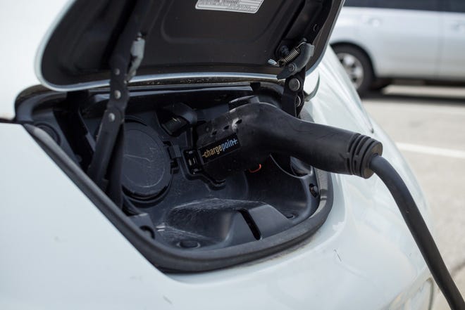 An electric vehicle plugs in to a Level 2 charging station in Olathe.